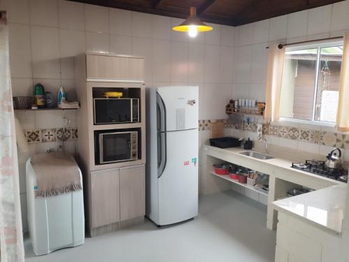 a kitchen with two refrigerators and a microwave at Chalé da Val in Palhoça
