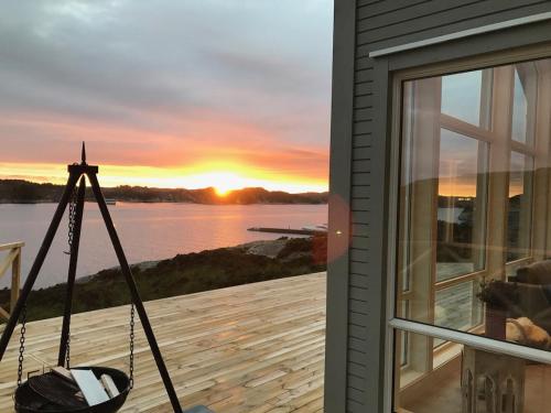 a view of a sunset from the deck of a house at House by the fjord - Ocean view and jacuzzi in Forland