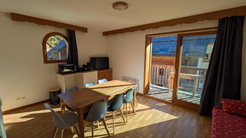 a dining room with a table and chairs and a window at Appartement 4 pièces pour 6-8 personnes, 3 chambres, 2 canapés-lit double dans le salon, au pied des pistes et piscine l'été, wifi fibre in Arvieux