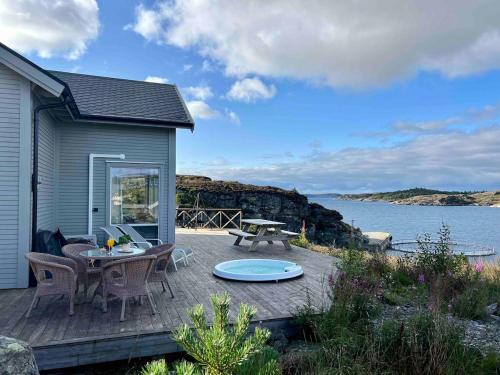 a patio with a table and chairs and the ocean at House by the fjord - Ocean view and jacuzzi in Forland