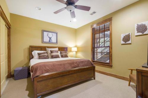 Un dormitorio con una cama y un ventilador de techo. en Taneycomo Retreat - Lakefront Condo, en Branson