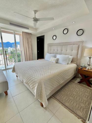 a bedroom with a large bed with two clocks on the wall at Grand Venetian Beachfront Condos in Puerto Vallarta