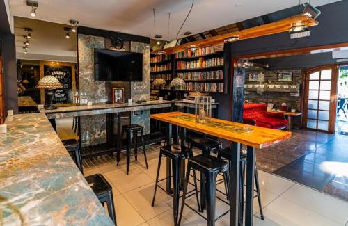 a bar with a wooden counter and stools in a room at F&F alojamiento in Punta del Este