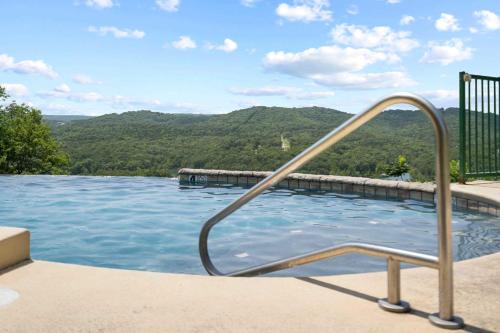 a swimming pool with a hand rail in the water at Sunset Retreat - 3 Min from Silver Dollar in Branson
