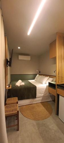 a bedroom with a large bed and a table at Hospedagem Moderna em Container in Foz do Iguaçu