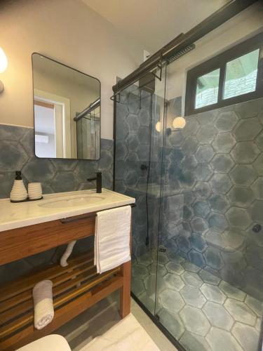a bathroom with a shower with a sink and a mirror at Hospedagem Moderna em Container in Foz do Iguaçu