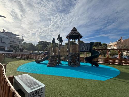 un parque infantil con un tobogán sobre una alfombra azul en Villa Lynn, en Atenas