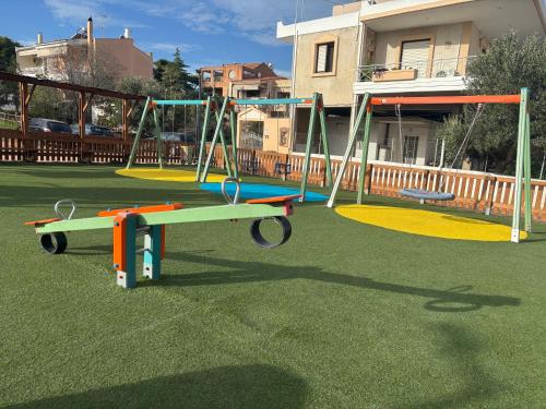 un grupo de columpios en un parque infantil en un patio en Villa Lynn, en Atenas
