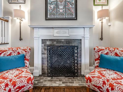 een woonkamer met twee stoelen en een open haard bij Spacious 4BR Tulsa Home with Patio in Tulsa