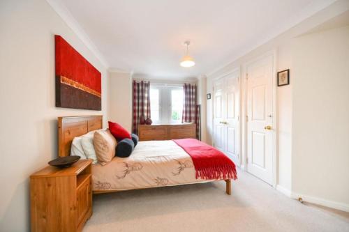 a bedroom with a bed with a red blanket at Amazing Apartment by The Wallace Monument in Stirling