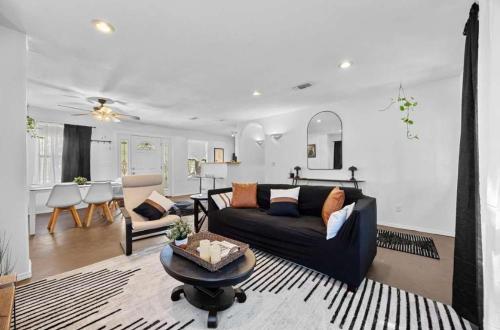 a living room with a black couch and a table at Lake Travis Retreat with Spacious Outdoor Areas in Austin