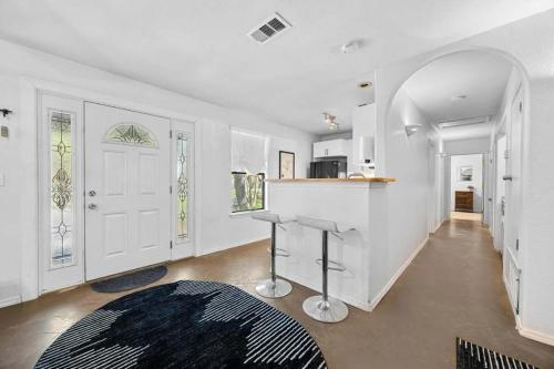 a white room with a kitchen with a counter and a door at Lake Travis Retreat with Spacious Outdoor Areas in Austin