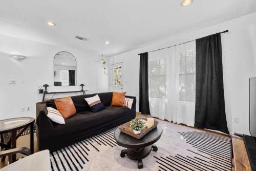 a living room with a black couch and a table at Lake Travis Retreat with Spacious Outdoor Areas in Austin