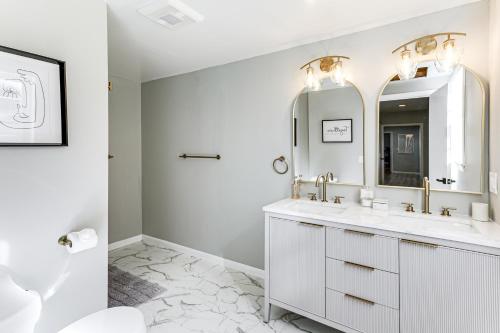 Un baño blanco con dos lavabos y un espejo. en 2 Mi to USCG Academy! Convenient New London Home, en New London