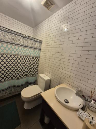 a bathroom with a white toilet and a sink at Apartamento tipo Loft Zona 4 Ciudad Capital, Guatemala in Guatemala