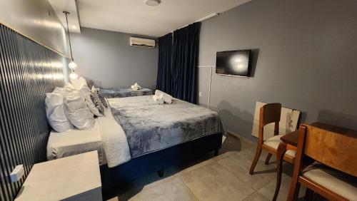 a small hotel room with a bed and a chair at Essencial Hotel Spa in Mendoza