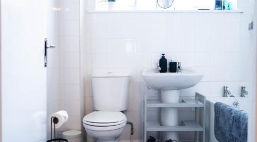 a white bathroom with a toilet and a sink at Langcliffe House - 3 Bed, Sleeps 5 - Garden, Parking & Wifi - Warwick in Warwick