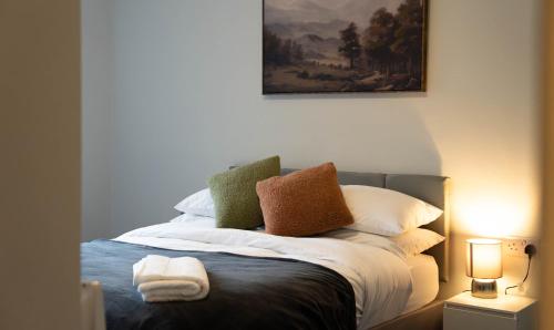 a bedroom with a bed with pillows and a painting at Langcliffe House - 3 Bed, Sleeps 5 - Garden, Parking & Wifi - Warwick in Warwick