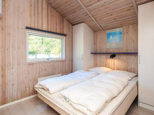 a large bed in a room with wooden walls at Seaside Haven with Spa - By Traum Ferienwohnungen in Sønder Bjert