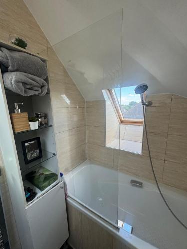 a bathroom with a tub and a shower with a window at Central London double bed apartment Free Parking Incl Stays upto 6 in London