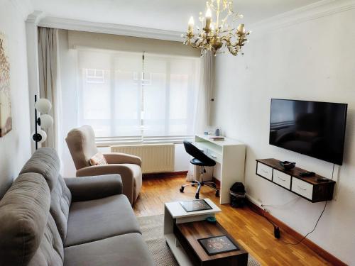 a living room with a couch and a flat screen tv at Confortable y luminoso apartamento in Valladolid