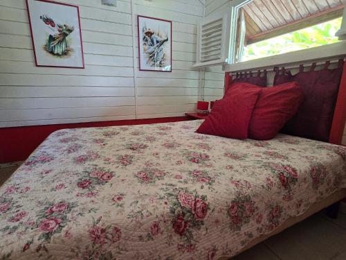 a bedroom with a large bed with red pillows at Chalet Plage et Kite in Le Vauclin
