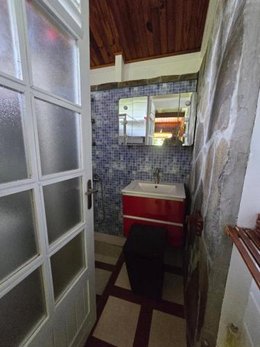 a bathroom with a sink and a toilet and a door at Chalet Plage et Kite in Le Vauclin