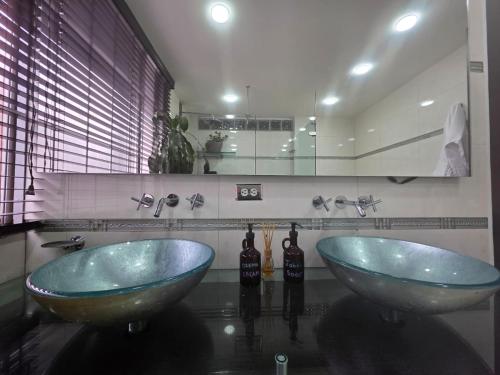 two blue sinks in a bathroom with a mirror at Freyja Hostal Boutique - Café Bistró in Bogotá