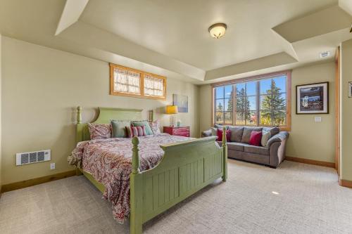 a bedroom with a green bed and a couch at Ravenswood- Lake views- downtown greystone with air conditioning in McCall
