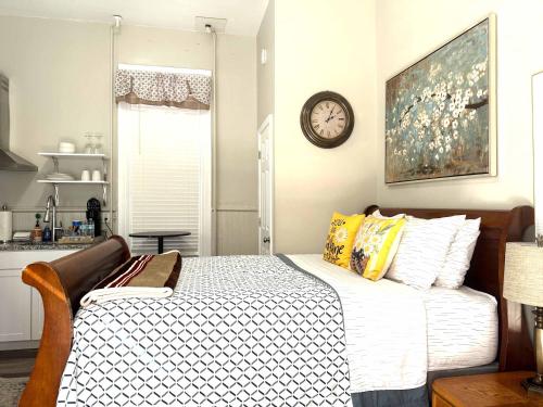 a bedroom with a bed with a clock on the wall at Cozy nest private porch museums free parking in Richmond