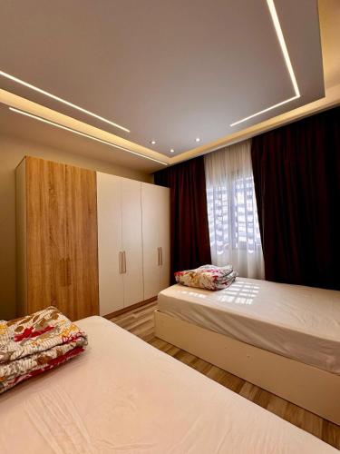 a bedroom with two beds and a window at the luxury apartment in Madinaty