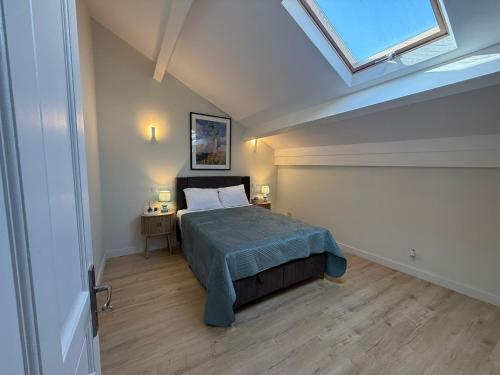 une chambre avec un lit et une lucarne dans l'établissement Casa De Mariposas Viola, à Faro