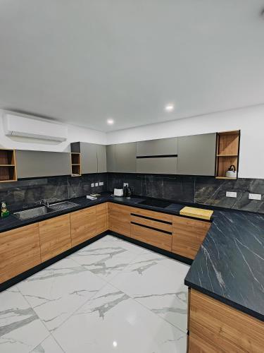 a large kitchen with wooden cabinets and black counter tops at Large Deluxe Apartment in St. Paul's Bay
