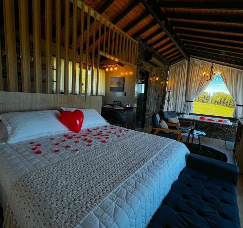 a bedroom with a large bed with a red heart pillow at Chalé Heinz in Rancho Queimado