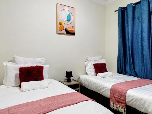 two beds sitting next to each other in a room at Apartment near the University of Botswana in Gaborone