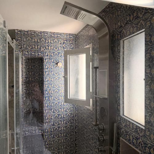 a bathroom with a shower with blue tiles at Casaflor Tunis in Tunis