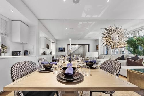 a dining room and living room with a table and chairs at Luxury Villa by Hyde Park in London