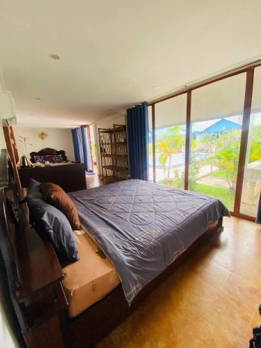 a bedroom with a large bed with a large window at Orchid bokor family guest house in Kampot