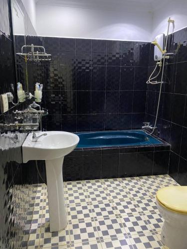 a bathroom with a sink and a blue tub at Orchid bokor family guest house in Kampot