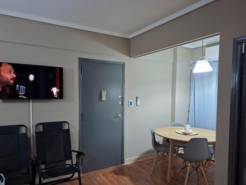 a room with a table and chairs and a tv at Neptuno VI in Mar del Plata