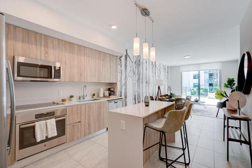 a kitchen with wooden cabinets and a kitchen island at 3900-719JC DESIGN DISTRICT, CONDO 1 BEDROOM /1 BATHROOM & BAYVIE in Miami