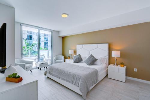 a bedroom with a white bed and a large window at 3900-719JC DESIGN DISTRICT, CONDO 1 BEDROOM /1 BATHROOM & BAYVIE in Miami
