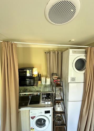 a small kitchen with a washer and dryer at Cosy & new CNZhouse with yard in Christchurch