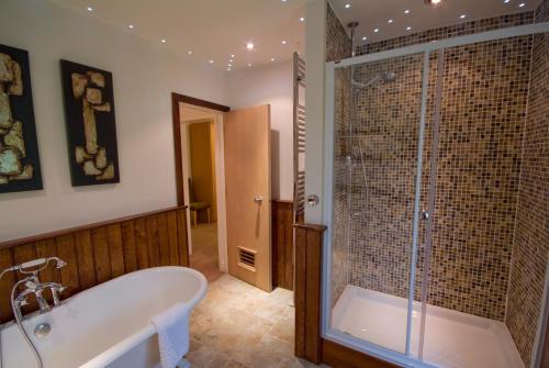 a bathroom with a tub and a glass shower at Exeter Court Hotel in Exeter