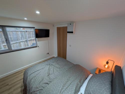 a bedroom with a bed and a window at Modern Tiny Garden House in York