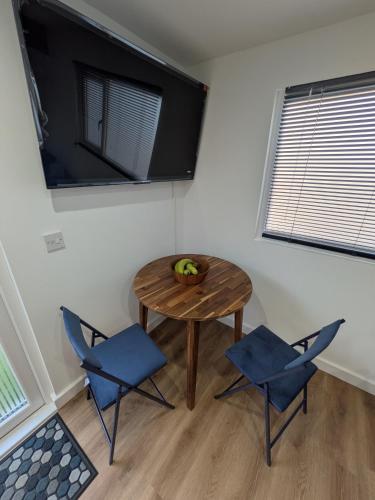 a room with a table and two chairs and a television at Modern Tiny Garden House in York