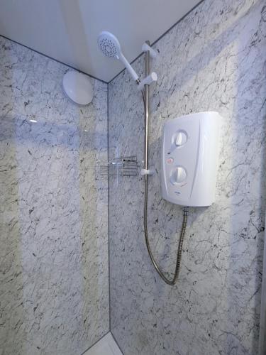 a shower with a shower head in a bathroom at Modern Tiny Garden House in York