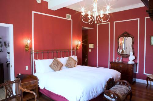 a bedroom with a large bed with red walls at Wedmore Place in Williamsburg