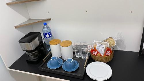 Eine Theke mit Kaffeemaschine, Tassen und Tellern. in der Unterkunft Suite no centro de Doutor Pedrinho in Rio Forcação