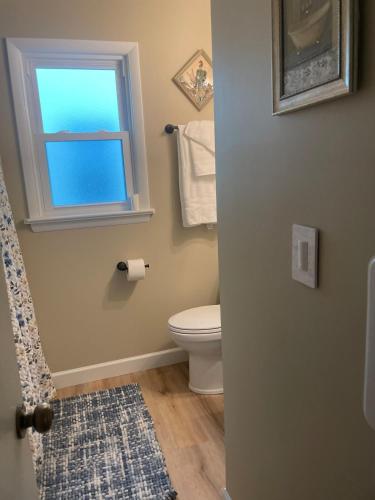 a bathroom with a toilet and a window at Newly renovated 3-bedroom lakeside home in Euclid